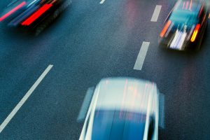 From the driver’s point of view, another car ahead makes a lane change on a rainy day