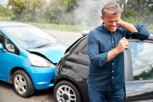 A woman holds her neck in pain after a rear-end collision