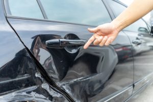 man pointing out hit-and-run damage