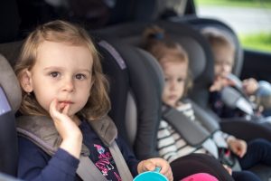 three small children in car seats