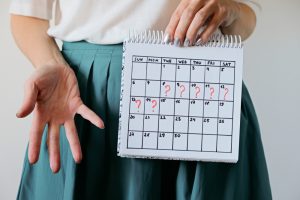 woman holds calendar reflecting menstruation cycle