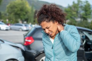 woman holds neck after car crash