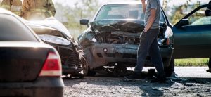 man walking among accident wreckage