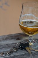 set of car keys next to glass of beer