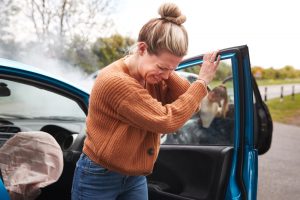 woman winces in pain after auto wreck