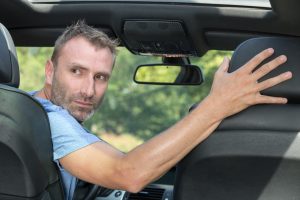 man-backing-up-in-a-car
