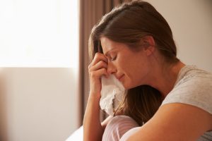 woman-crying-while-sitting-on-her-bed