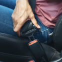 woman hand fastening seatbelt