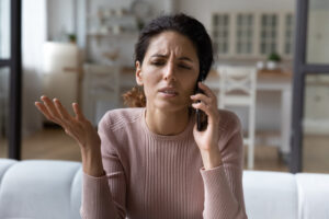 a confused young woman talking on the phone