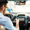 A man texts on his cellphone while driving. Learn how to prove a driver was texting while driving at the time of your accident.
