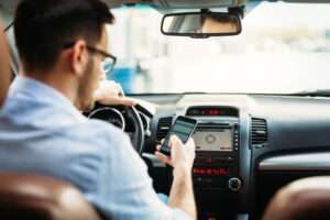 A man texts on his cellphone while driving. Learn how to prove a driver was texting while driving at the time of your accident.