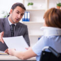 Lawyer sits at desk with client and explains how to seek damages for injuries caused by rear-end collisions.