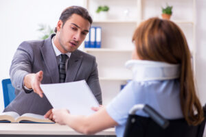 Lawyer sits at desk with client and explains how to seek damages for injuries caused by rear-end collisions.